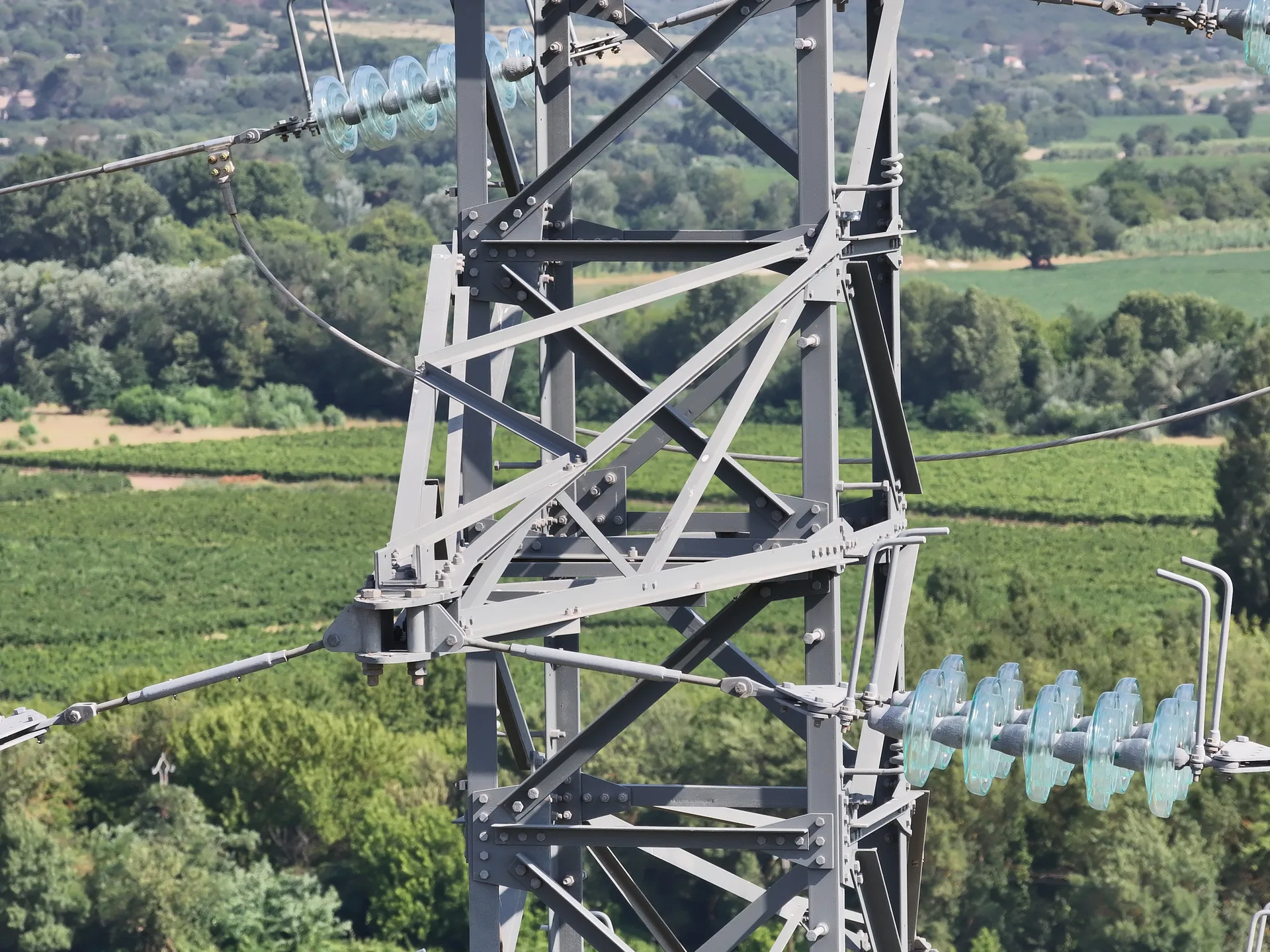 Isolateurs en verre d'un pylône électrique inspectés en gros plan par drone